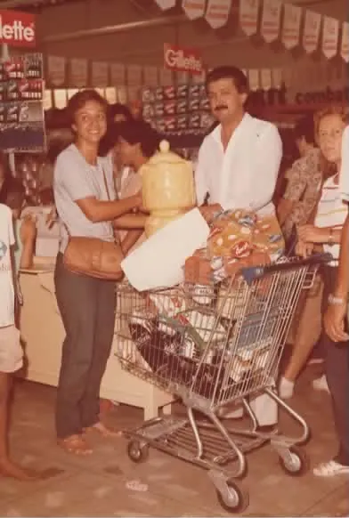 Cliente com carrinho cheio no supermercado, anos 70